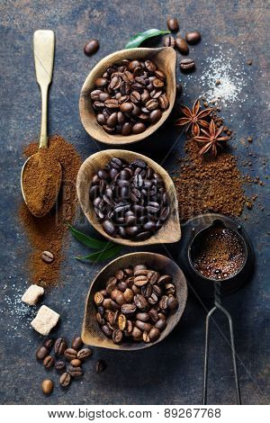 Top view of three different varieties of coffee beans on dark vintage background