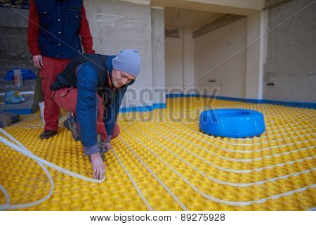 group of workera installing underfloor heating and colling in modern home