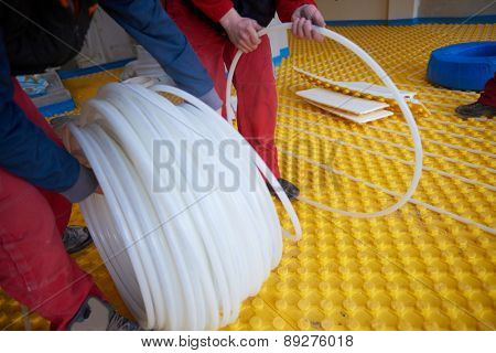 grouo of workera installing underfloor heating and colling in modern home