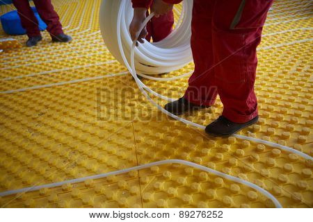 grouo of workera installing underfloor heating and colling in modern home