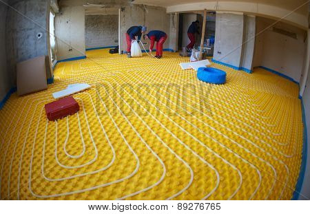 group of workera installing underfloor heating and colling in modern home