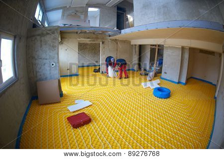 group of workera installing underfloor heating and colling in modern home