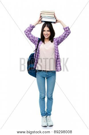 Full length portrait of a smiling young wowan holding books on head over white background and looking at camera