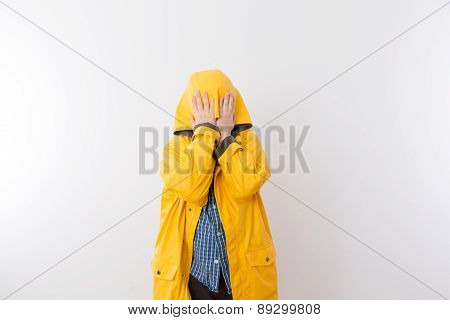 Child Wearing Yellow Rain Coat Hiding Face In Hood
