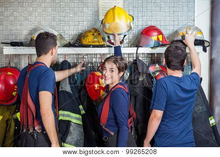 Male and female firefighters getting ready in fire station