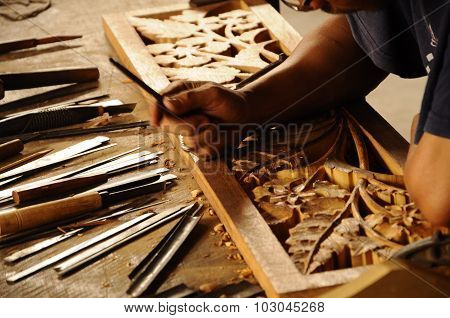 Skilled craftsman doing wood carving using traditional method