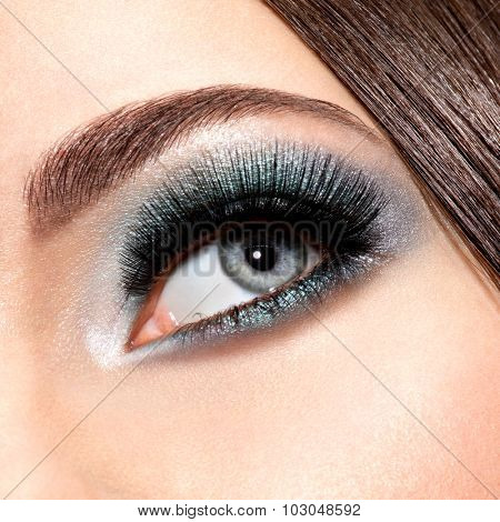 woman's eye with turquoise makeup. Long false eyelashes. macro shot  