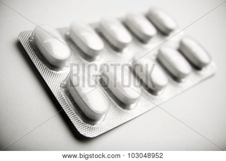 Forefront of a white medicine pills in blister pack.