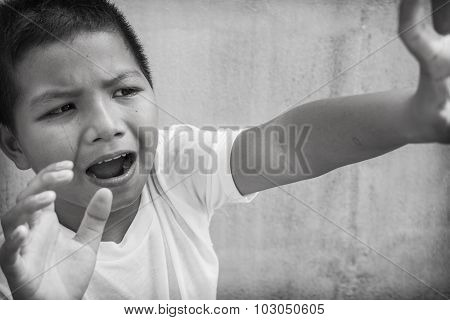 Asian child protecting himself from physical abuse