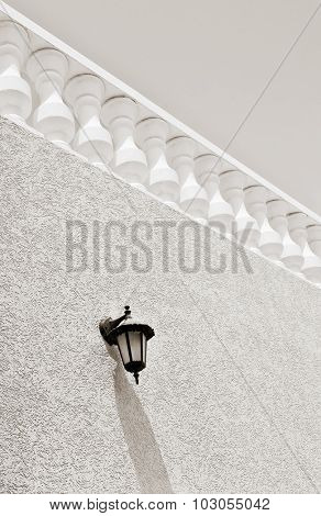Retro style terrace railing in perspective. A classic lamp mounted on the wall. outdoor shot.