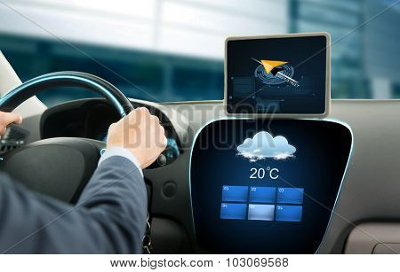 transport, business trip, technology and people concept - close up of businessman driving car with navigator on tablet pc and on board computer showing weather forecast