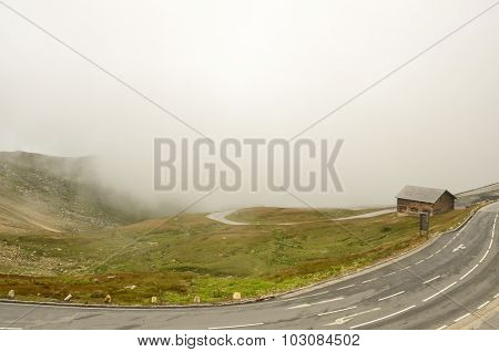 House standing on a mountain in the clouds