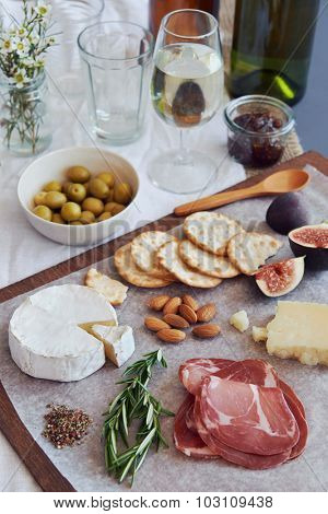 Selection of gourmet cured meat charcuterie salami, coppa, with brie camembert gruyere cheese served with olives nuts and fruit