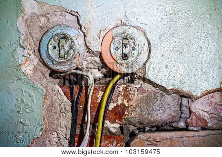 Two old electric switches in obsolete wall with wires, a lot of copy space