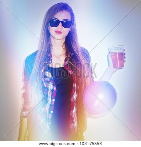 Cool teenage girl with sunglasses and glass of beer