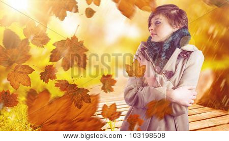 Thoughtful woman in winter coat against wooden trail across countryside