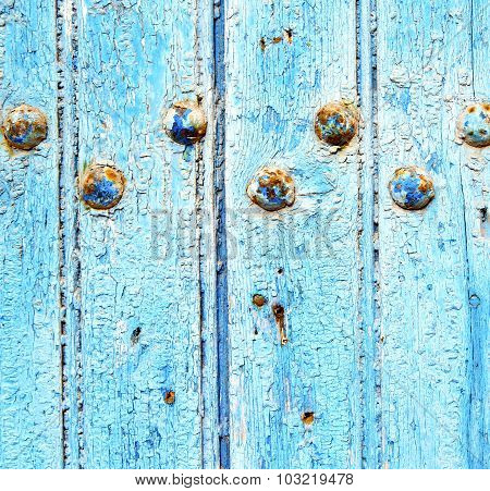 Stripped Paint In The Blue Wood Door And Rusty Nail