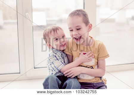 two boys laugh by playing
