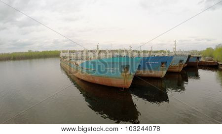 SAMARA - MAY 10, 2015: Several tankers on moorage in Volga river at spring cloudy day. Aerial view video frame