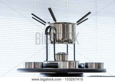 modern dishware, fondue set on window background
