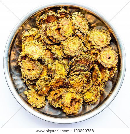 Bittergourd chips kept on a glass bowl on a plain background