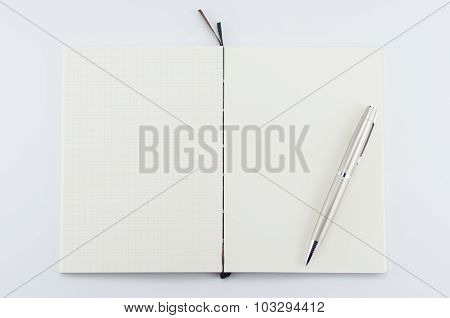 Opened notepad with pen on white background.