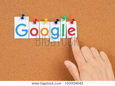 New Google logotype printed on paper, cut and pinned on cork bulletin board with hand