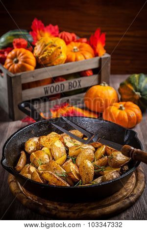Rustic baked potatoes with herbs and pumpkins
