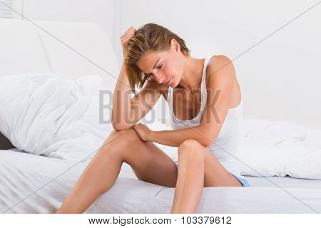 Young Woman Sitting On Bed