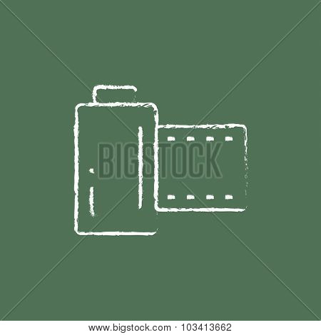 Camera roll hand drawn in chalk on a blackboard vector white icon isolated on a green background.