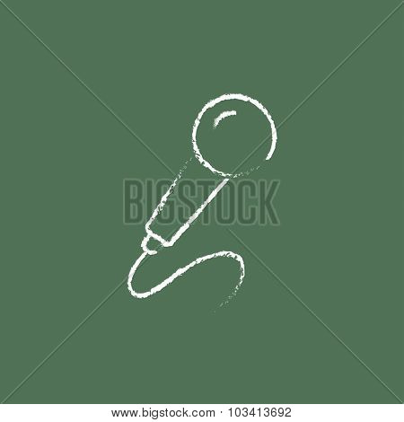 Microphone hand drawn in chalk on a blackboard vector white icon isolated on a green background.