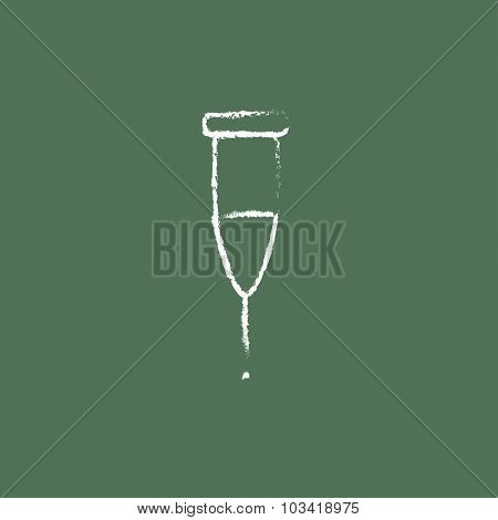 Crutch hand drawn in chalk on a blackboard vector white icon isolated on a green background.