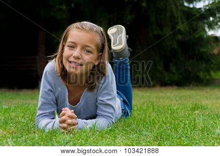 Happy child girl lay in grass smiling