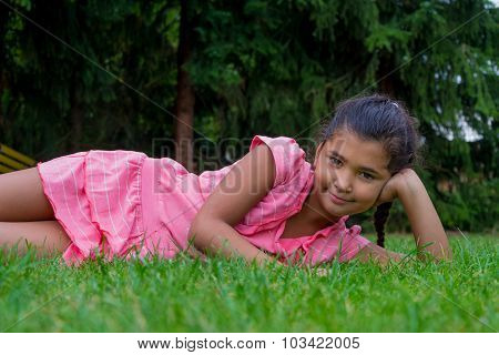 Small Gypsy Child Girl Lay Aside In Grass Smiling Happy Clothed In Dress