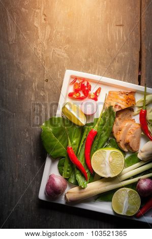 Ingredients set for Thai spicy soup (Tom-yum) include lemon galangal red chili red onion lemongrass and kaffir lime leaf on wood table in morning scene