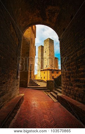 San Gimignano Sunset From A Tunnel, Towers In Central Erbe Square. Tuscany, Italy, Europe.