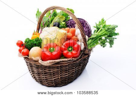 Basket full of fresh summer organicc produce vegetables from the farmers market, tomatoes, peppers, capsicums, celery, cabbage, cauliflower, mushroom, leafy greens