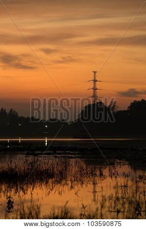 Silhouette Of High Voltage Post With Huayyang Reservoir
