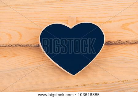 Small wooden framed blackboard hanging on wooden background. chalkboard with place for your text. copy space.