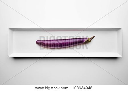 Long Eggplant Isolated On Blank White Plate