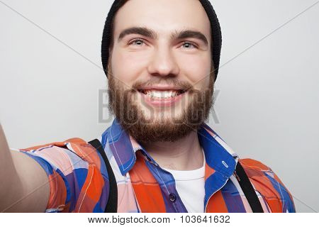 Tehnology concept: Happy selfie. Handsome young man  holding camera and making selfie and smiling.