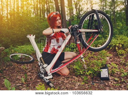 Young Sportswoman Bicyclist Repairing Her Mtb Bike In The Forest