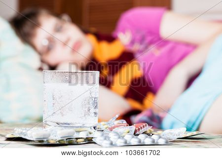 Glass With Dissolved Drug In Water And Pills