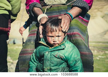 Tibetan kid in a steppe in Tibet.