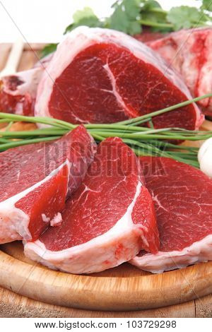 raw meat : fresh beef pork big rib and fillet with garlic and green stuff on wood isolated over white background