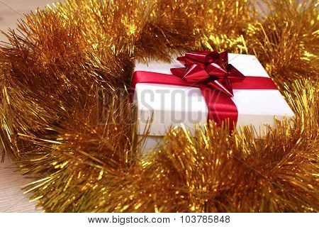 New Year gift on a golden tinsel background boly