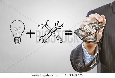 Close up of businessman drawing money making formula