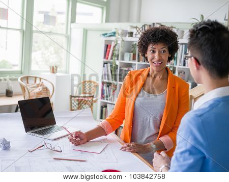 Two desingers working on a project together in office