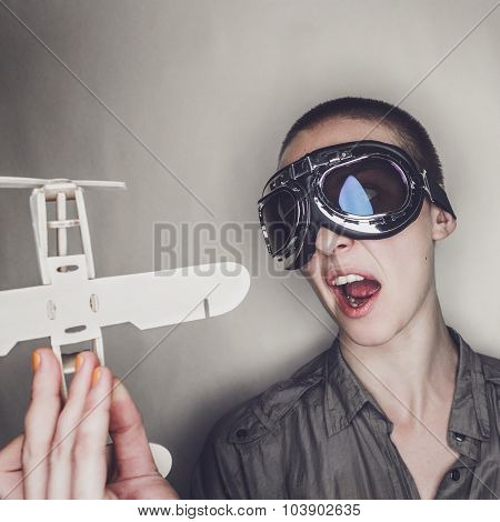 girl in retro pilot glasses with wooden plane