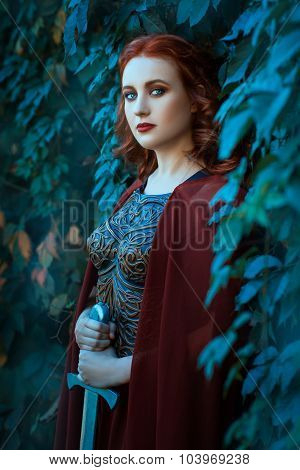 Girl With A Sword Standing In The Bushes Of Grapes.